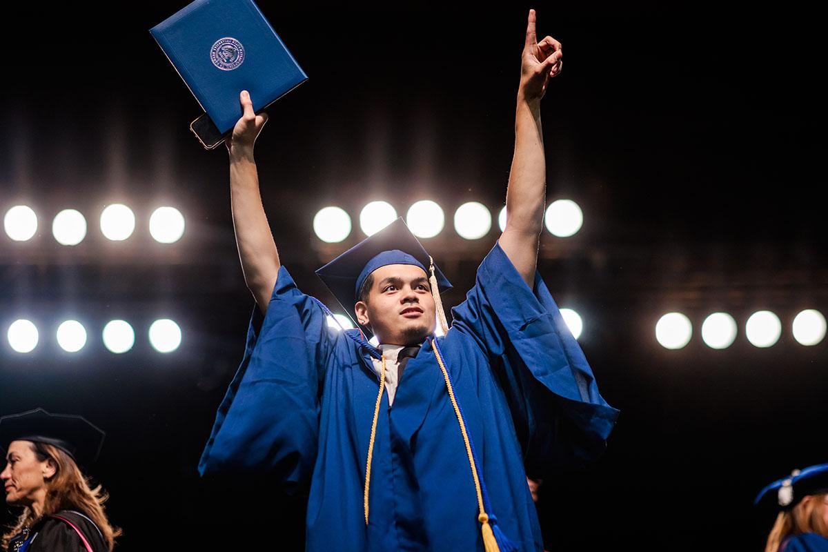 密歇根州立大学丹佛分校的毕业生自豪地接受他的文凭.