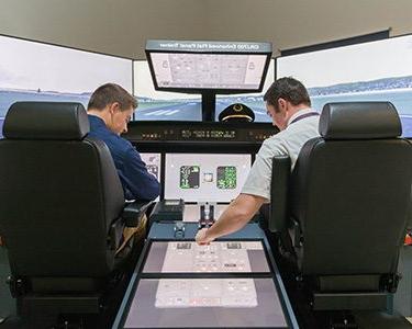 两名密歇根州立大学丹佛分校的学生在Auraria校区操作飞行模拟器.